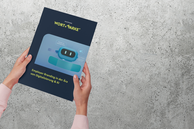 Foto von Händen, die das gedruckte GOLDSTÜCK Whitepaper zum Thema Employer Branding halten